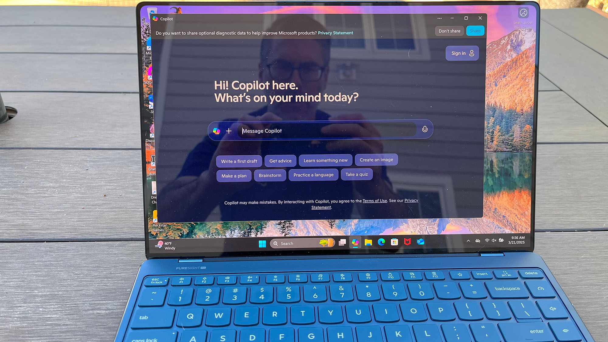A Lenovo Yoga Slim 9i sitting on a picnic table outside