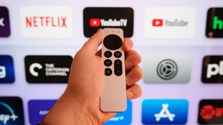 The Apple TV 4K (2022) remote in front of a TV with the tvOS home screen.