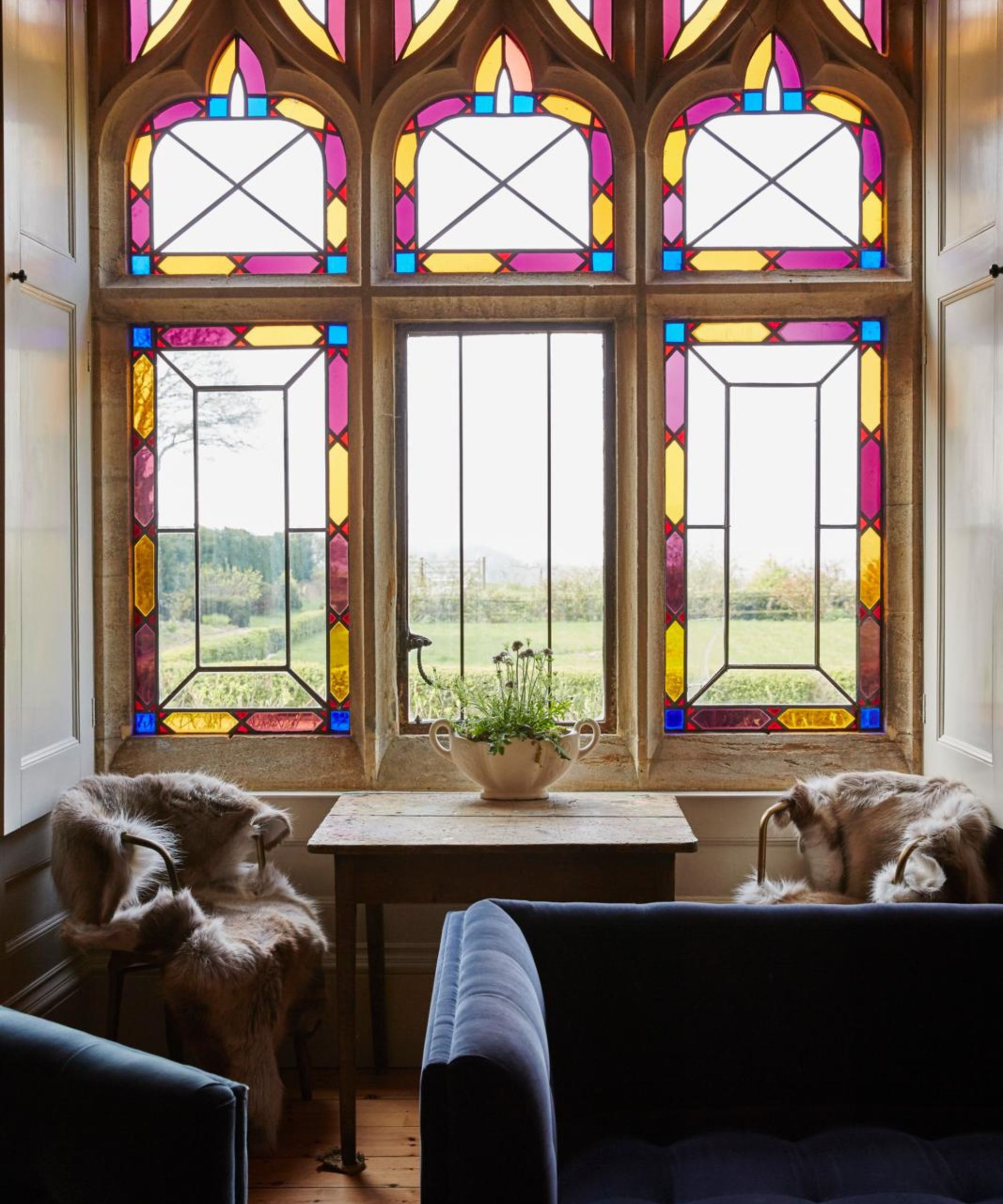 a cozy corner of a room with stained glass windows