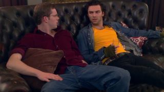 Russell Tovey and Aidan Turner sit having a conversation on their shared couch in Being Human.