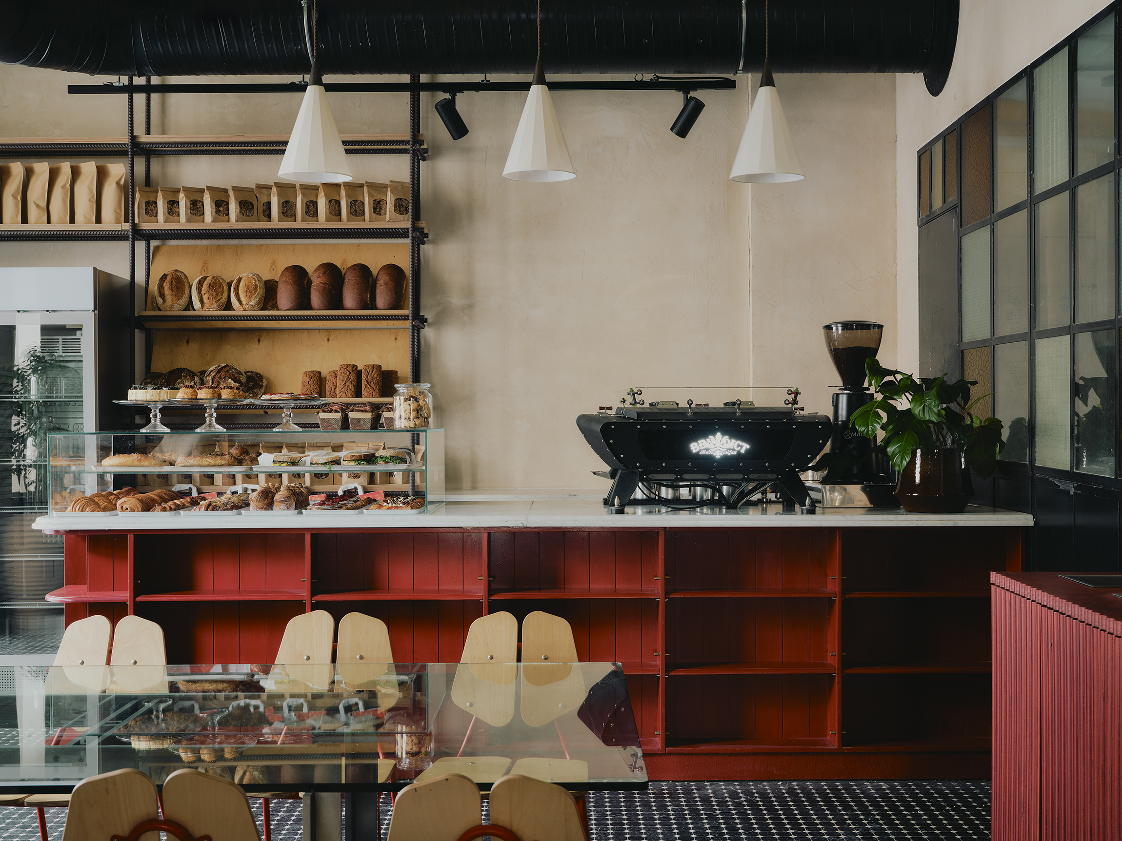 Interiors of a colorfully decorated hotel with a green, pink, and red palette, checkered or striped flooring, quirky, sculptural collectibles throughout, and lots of natural light.