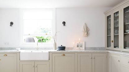 Scandinavian kitchen design - a bright white and cream calming kitchen with a candle on the counter