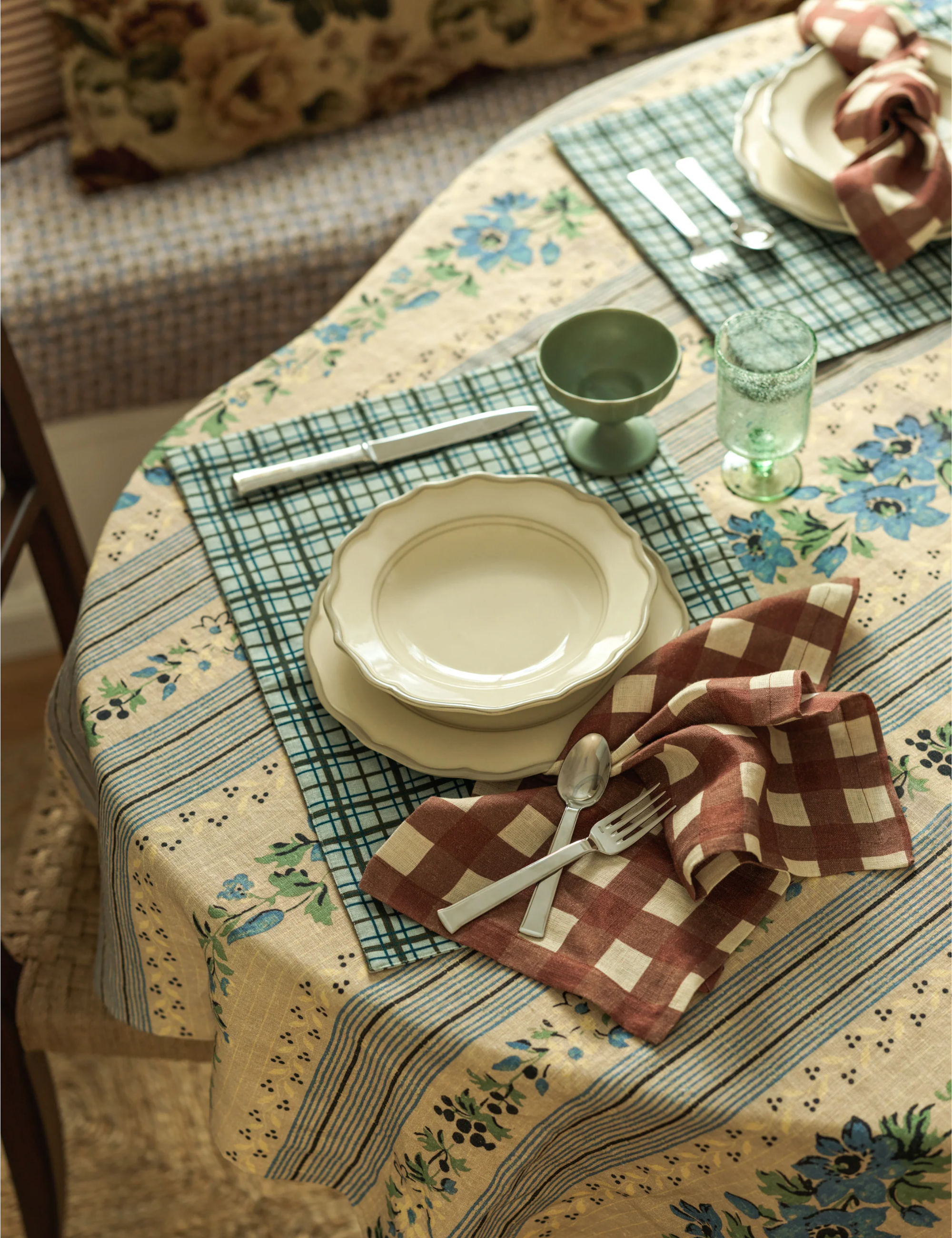Eclectic, pattern-drenched tablescape featuring florals, gingham, and plaid