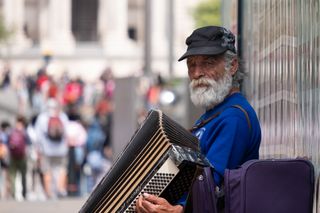 An old busker playing an accordion