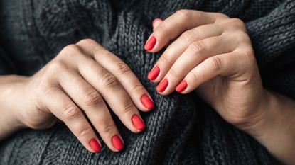 woman's hand with Red Painted Nails for winter