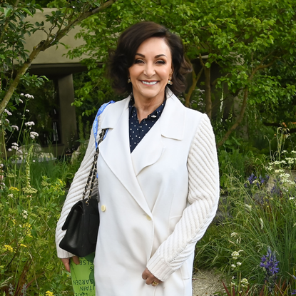 Shirley Ballas in white coat, with blue polka dot shirt underneath at Chelsea Flower Show.