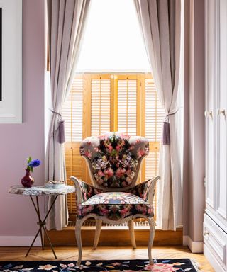 lavender painted bedroom with traditional upholstered chair