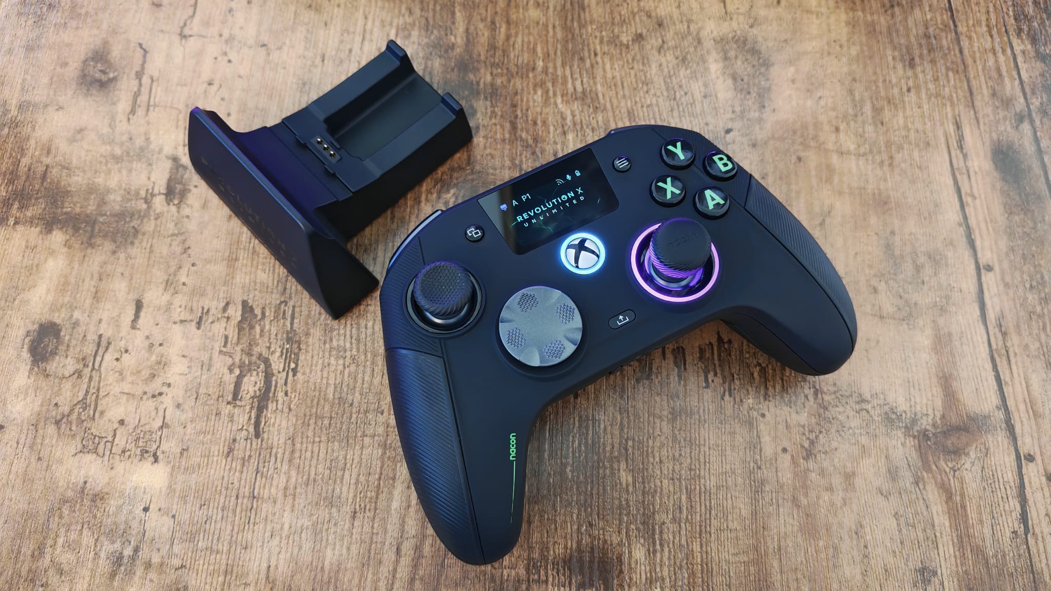 The Nacon Revolution X Unlimited review lying next to its charging stand