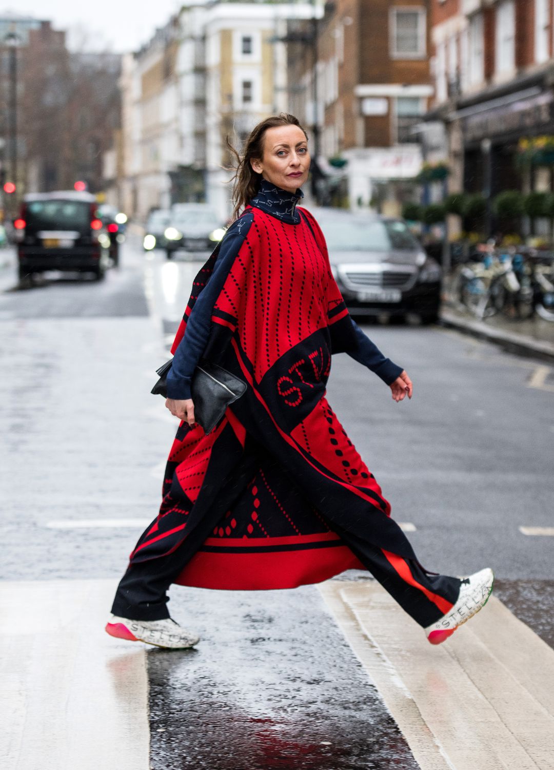 Kristine Kilty wears a Stella McCartney tracksuit, cape and trainers and a Kat Von D bag during London Fashion Week February 2022 on February 19, 2022 in London, England.