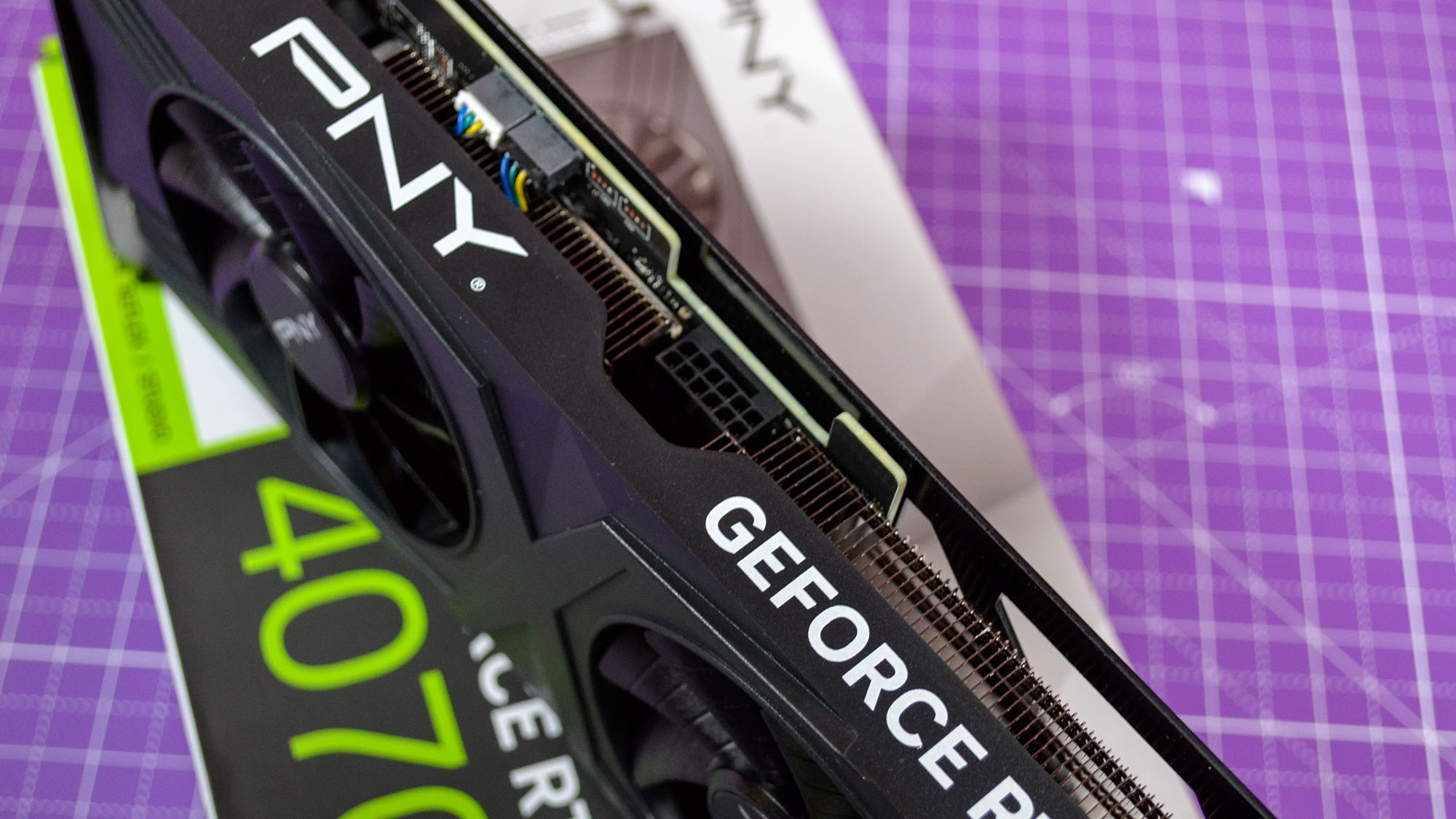 A PNY GeForce RTX 4070 Super Verto OC graphics card on a table with its retail packaging