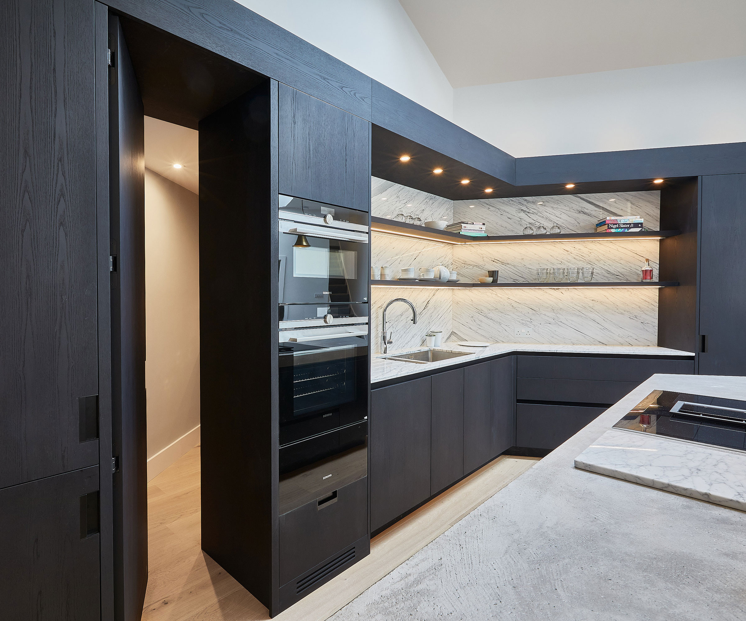 small black wooden kitchen with built-in ovens