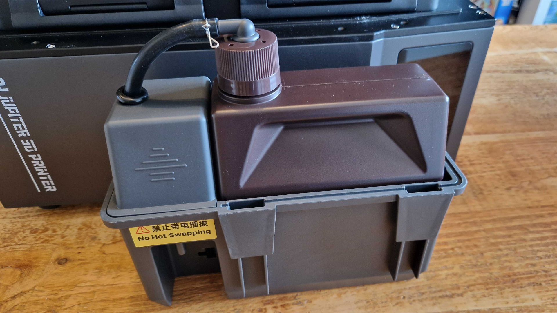 The resin auto-fill vat for the Elegoo Jupiter 2, sat on a wooden table
