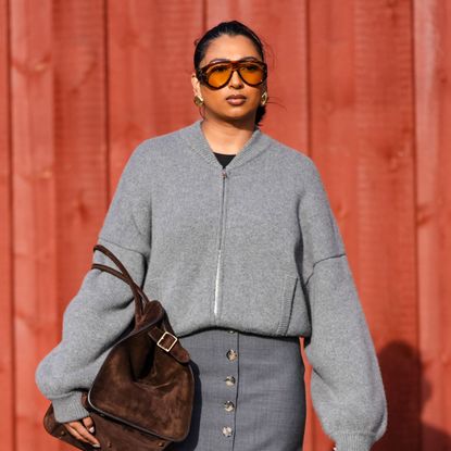 street style shot of woman with glowing skin wearing sunglasses