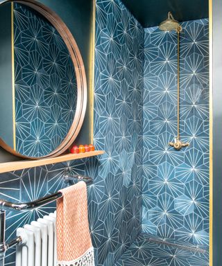 A walk-in shower with deep blue starburst tiles and brass fittings