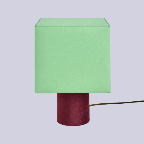 a mint and burgundy table lamp on a lilac background