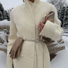 Woman wears cream coat and rope belt 