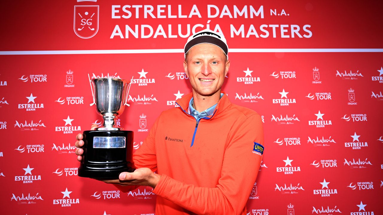 Adrian Meronk smiles as he holds up the 2023 Andalucia Masters trophy at Real Club de Sotogrande