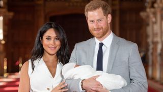 Prince Harry, Duke of Sussex and Meghan, Duchess of Sussex, pose with their newborn son Archie Harrison Mountbatten-Windsor during a photocall in St George's Hall at Windsor Castle on May 8, 2019 in Windsor, England.