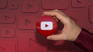 A hand holding a youtube logo glossy badge over dark red background