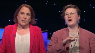 Amy Schneider stands in a pink jacket and white shirt, pictured next to Mattea Roach in conversation, wearing a salmon blazer and a cream sweater, on Jeopardy! Masters.