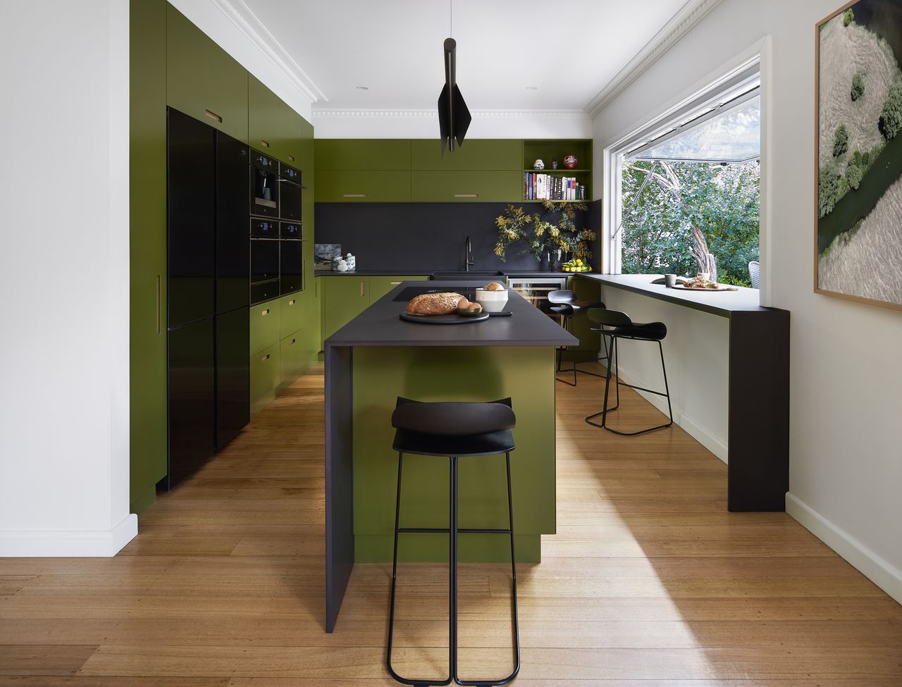 A dark green kitchen with black elements