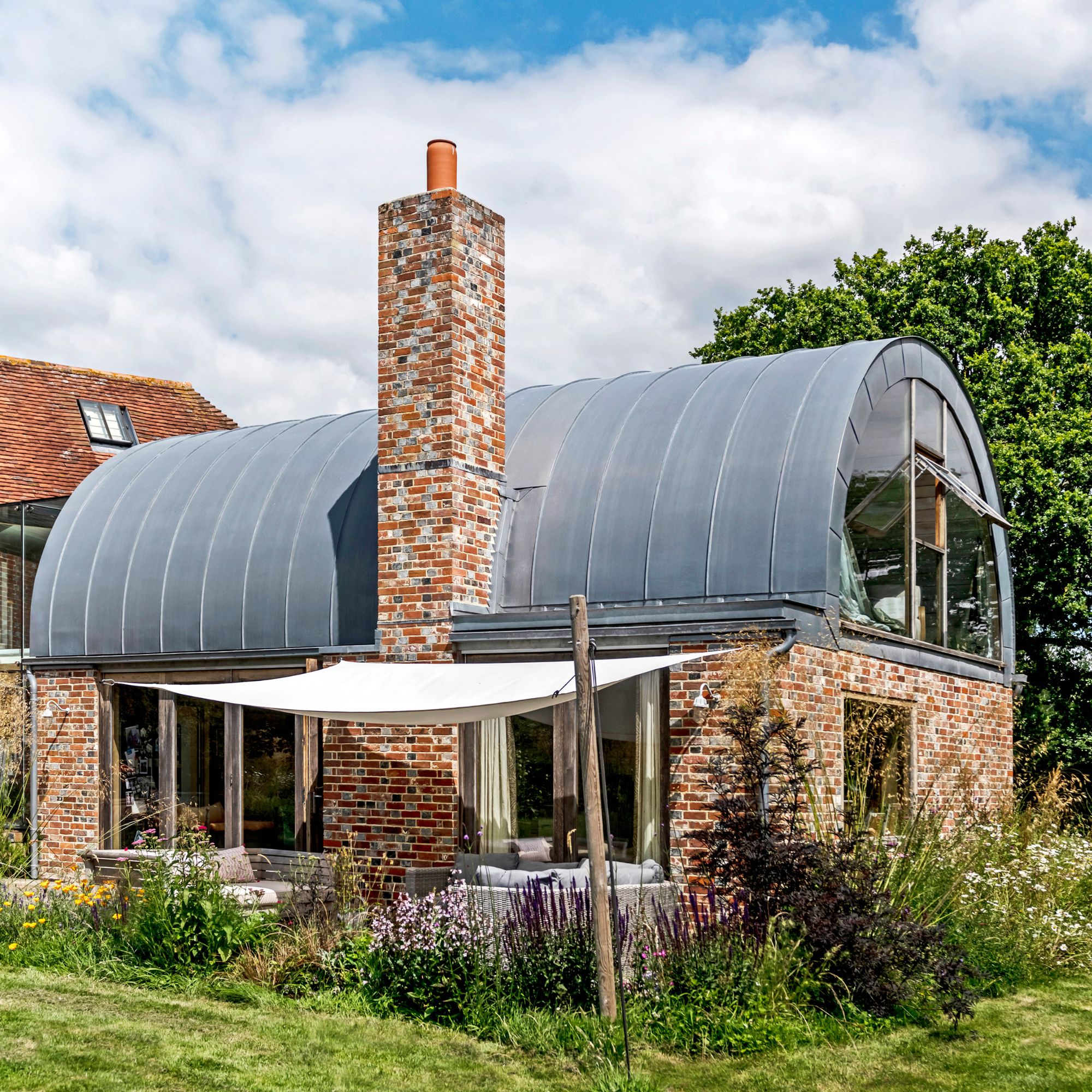 Exterior view of modern annexe extension with vaulted zinc roof