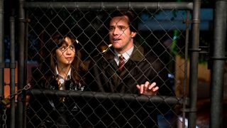 (L-R) Zooey Deschanel as Alison behind a chain link fence with Jim Carrey as Carl