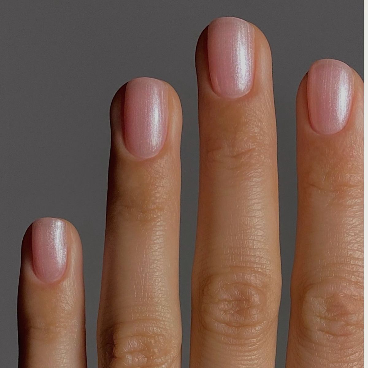 A close up of sheer shimmery pink nails