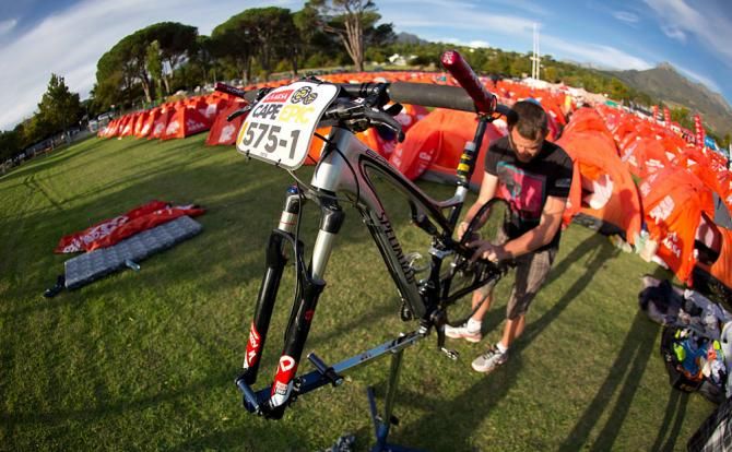 A bike mechanic works on a bike during stage 6