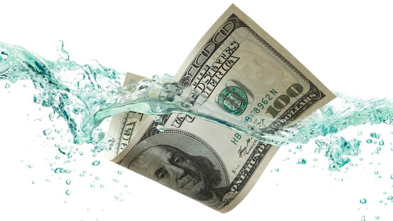 A $100 bill floats in water.