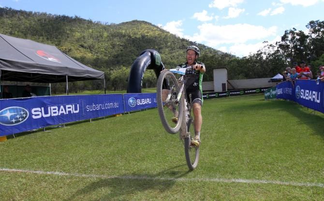 Jason English celebrates with a wheelie at the finish