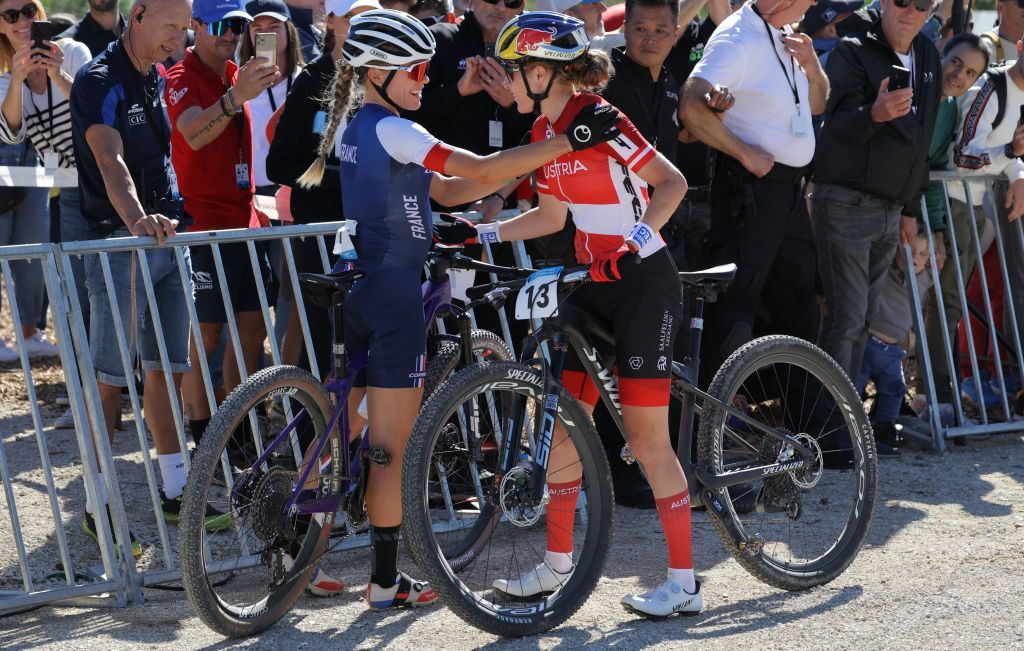 French Loana Lecomte L is congratulated by Austrias Laura Stigger R after she won the womens Elite Cross Country mountain biking test event at Elancourt Hill in Elancourt west of Paris on September 24 2023 Photo by Thomas SAMSON AFP Photo by THOMAS SAMSONAFP via Getty Images