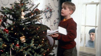a still from the home alone movie with Kevin McAllister decorating the christmas tree