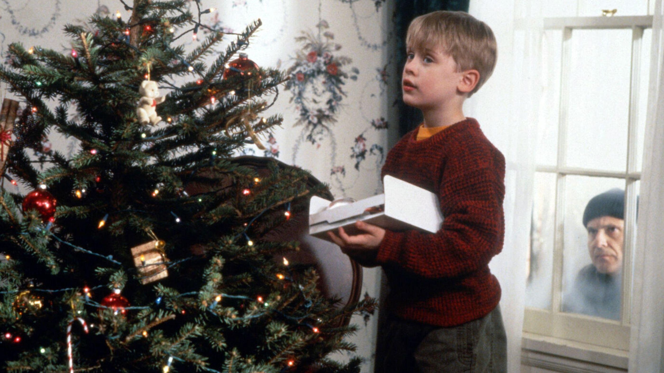 a still from the home alone movie with Kevin McCallister decorating the christmas tree