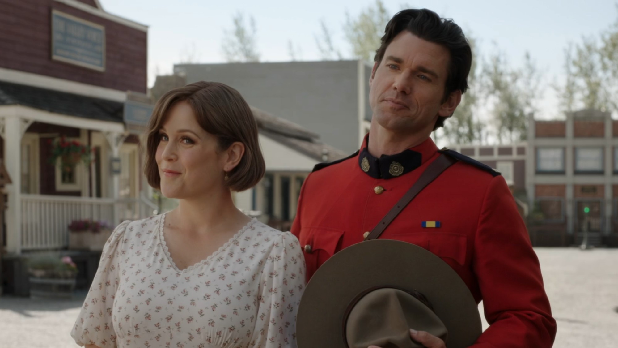 Elizabeth and Nathan standing next to each other and smiling on When Calls the Heart.