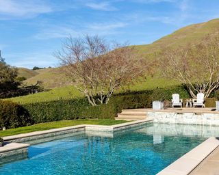 An example of pool landscaping ideas showing a pool surrounded by fields and hills
