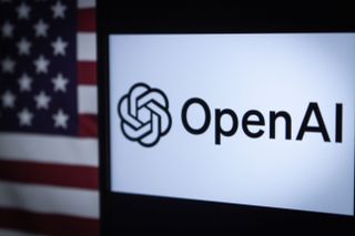 The OpenAI logo displayed on a screen with the flag of the United States in the background.