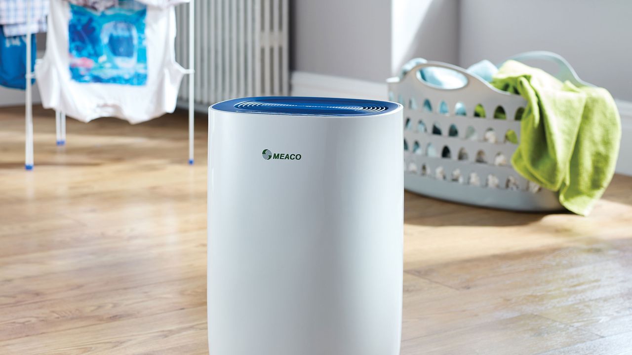 meaco dehumidifier in laundry room with basket of clothes