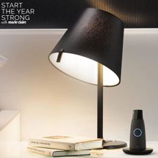 Image showing the Lumen metabolism device on a bedside table next to a lamp