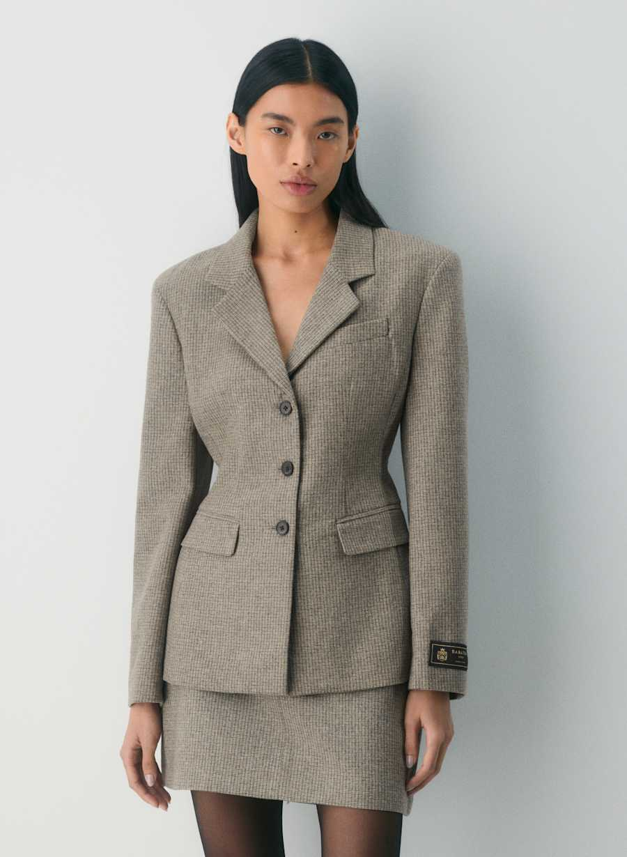 A model wearing a single-breasted blazer with a notched lapel and an hourglass silhouette.