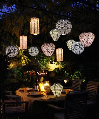 multi-colored solar lanterns hanging over the top of a patio