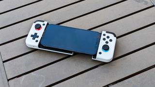 gamesir x2 holding iphone 12 pro laying on table