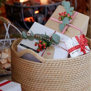 basket filled with Christmas gifts and berry sprigs