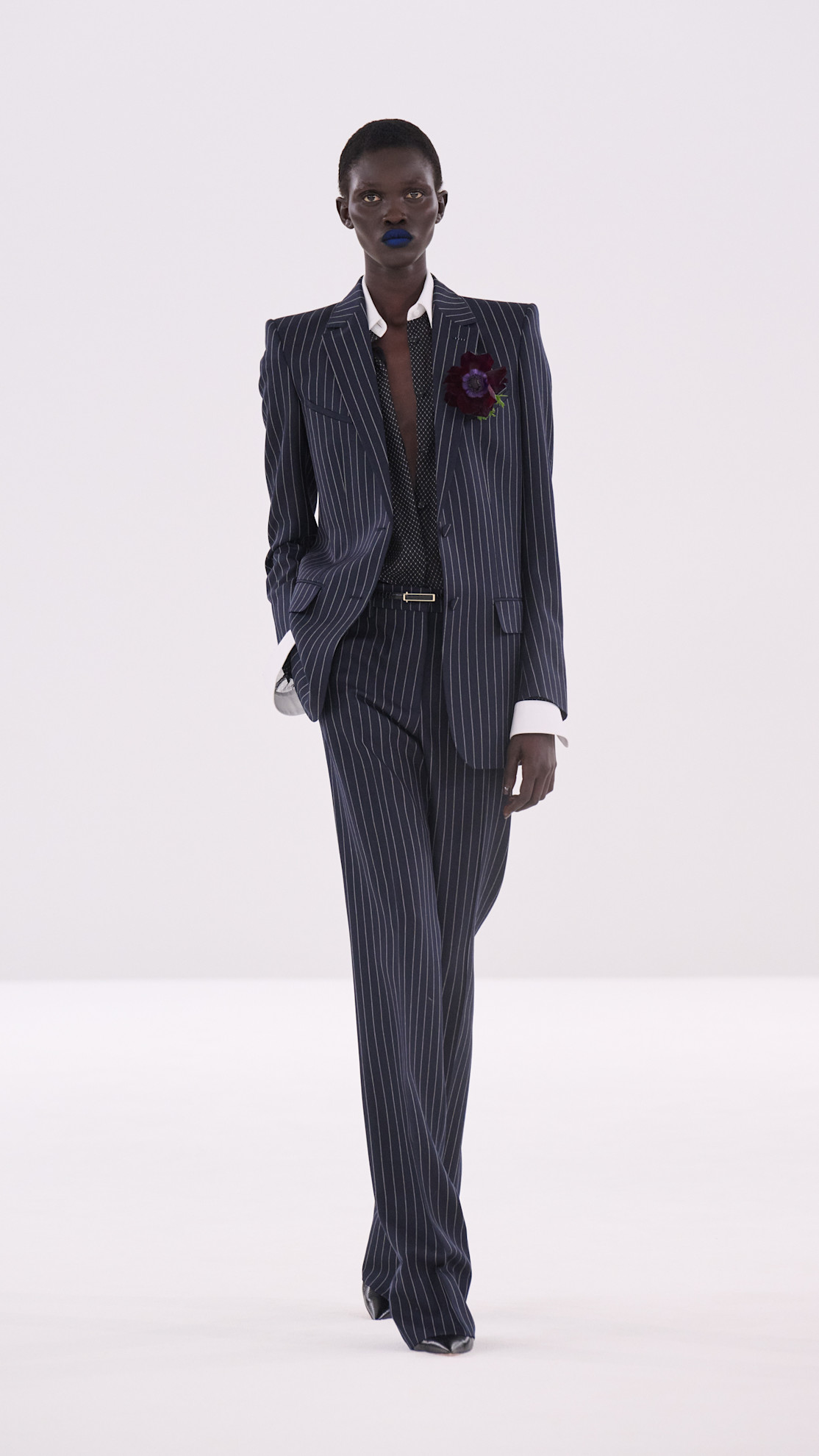 a Tom Ford model wearing a navy pinstripe suit on the runway