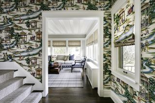 Hallway with wood floor and staircase with Chinoiserie wallpaper and view to living room