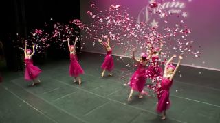 The ALDC throws rose petals in the air during their dance