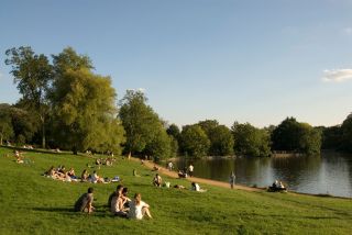 Young people relaxing beside Highgate pond on Hampstead Heath,