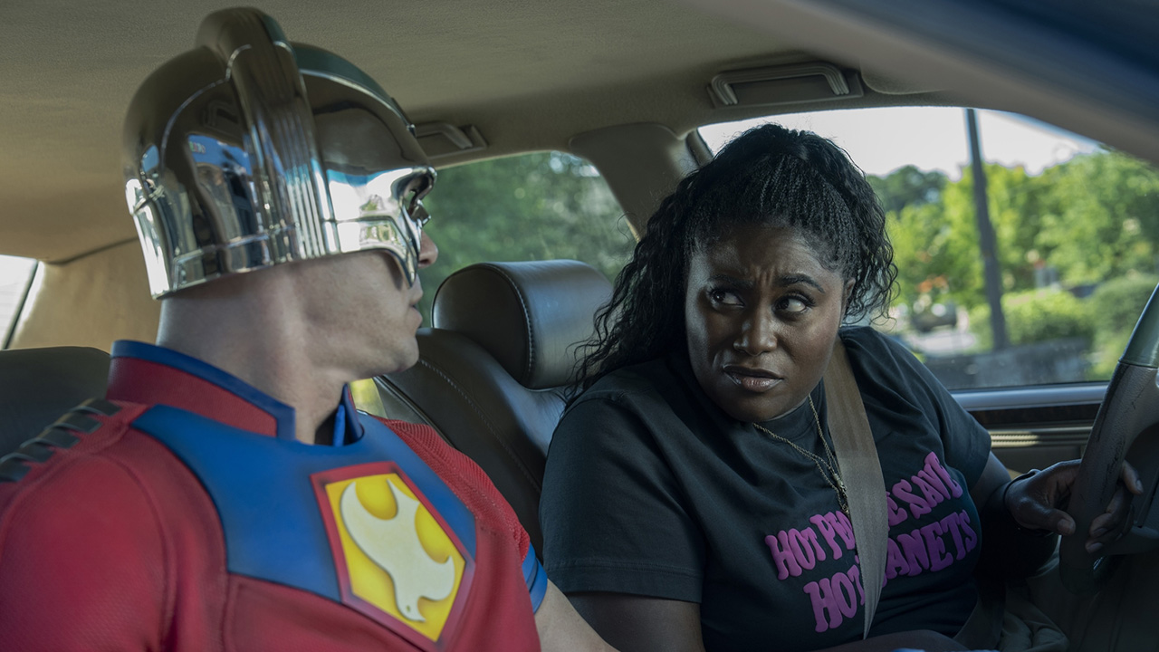 A suited-up Chris Smith talking to Leota in the latter's car in Peacemaker season 2