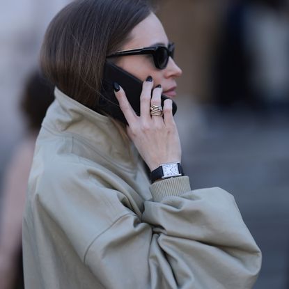 woman wearing trench with black nail polish
