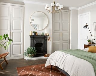 A white master closet in a bedroom with a traditional fireplace